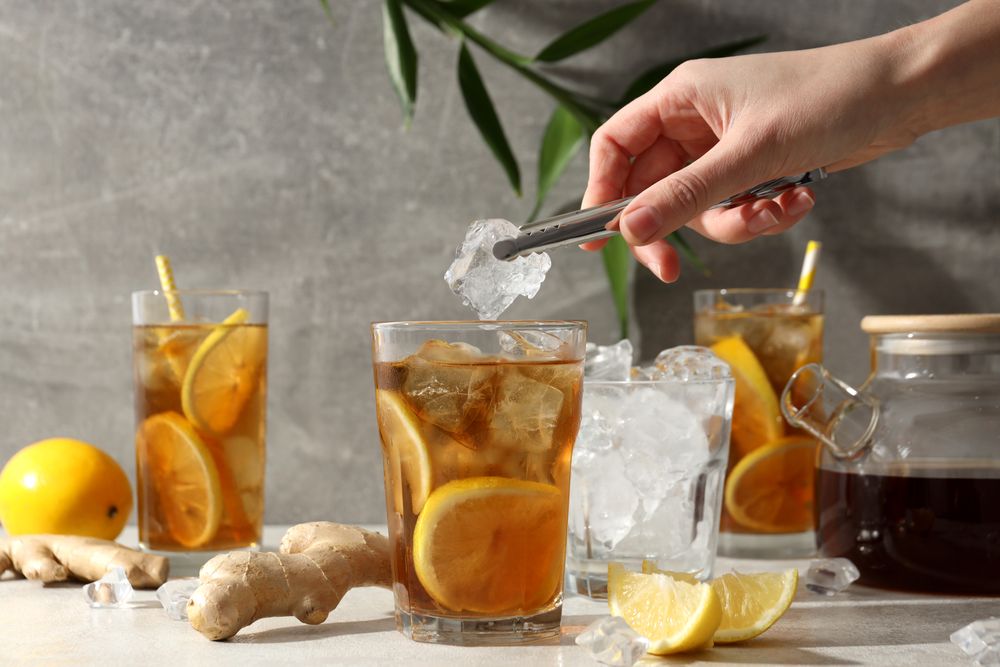 Cold tea with ice, orange slices and mint leaves and ginger