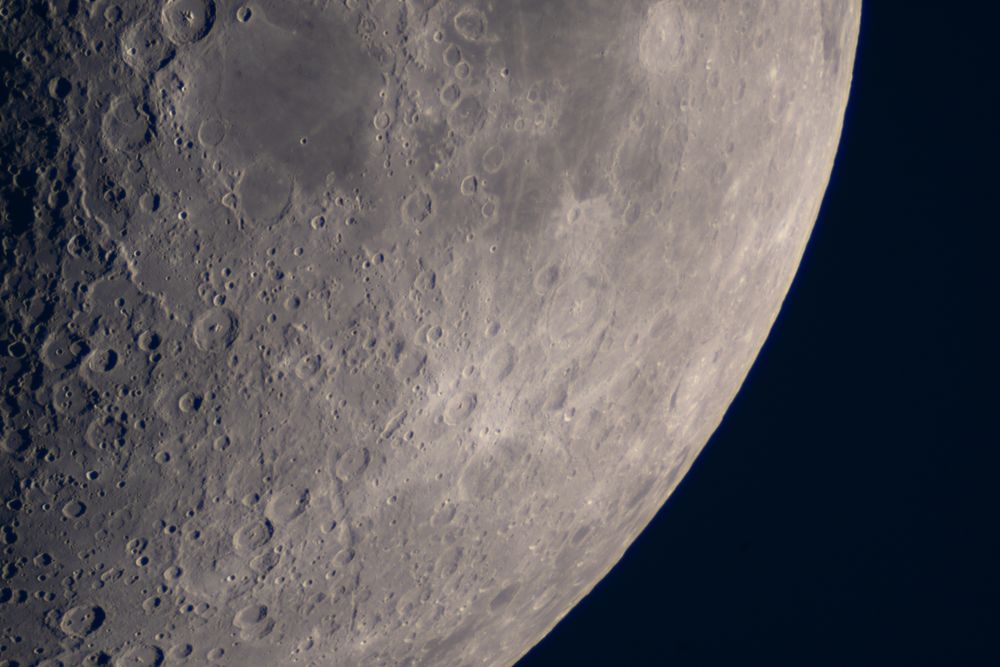 Moon surface close-up highlighting craters and rugged lunar terrain.