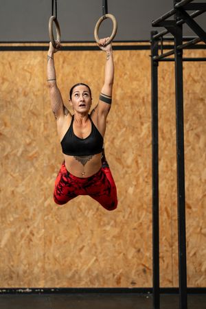 Woman swinging on gymnastic rings in the gym