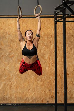 Woman swinging on gymnastic rings in the gym