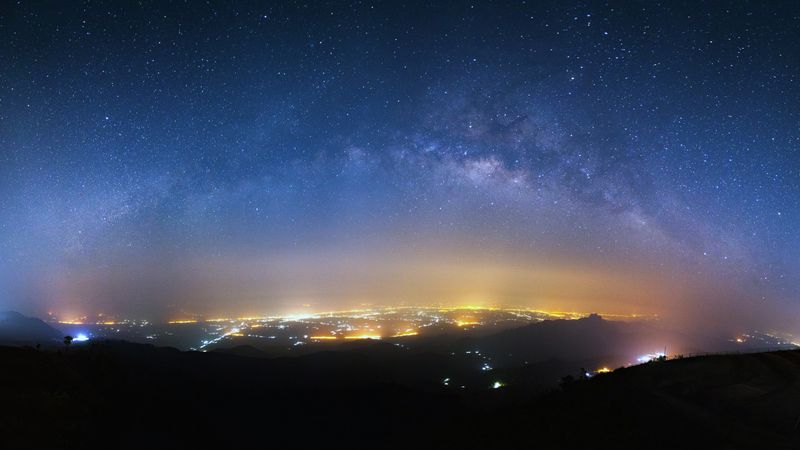 milky way galaxy and city light at Phutabberk Phetchabun in Thailand.Lo