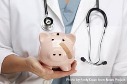 Doctor Holding Piggy Bank with Bandage on Face 48Bqgv