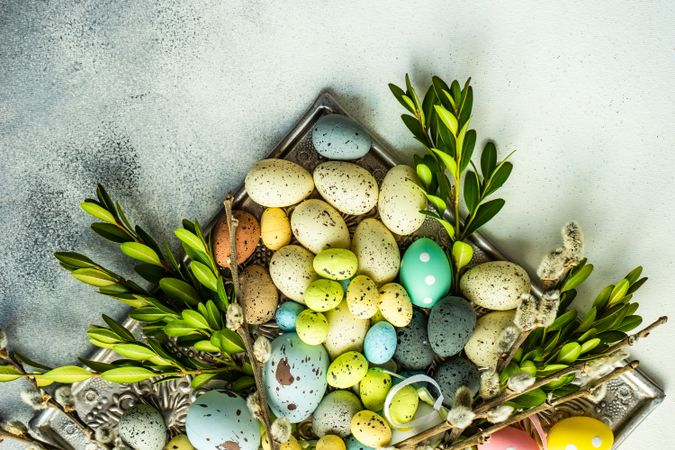 Easter card concept with top view of many colorful eggs and branches on table