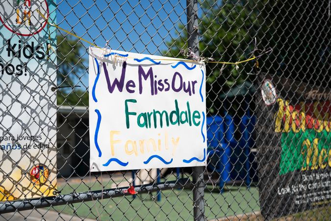 Handmade sign from teachers to students hanging on schoolyard fence