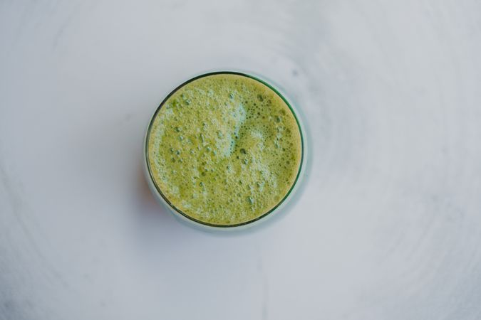 Delicious green smoothie with frothy in glass