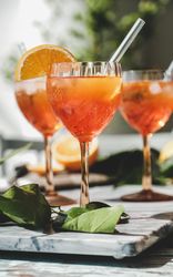 Three Aperol Spritz aperitif alcohol drink in glasses, vertical