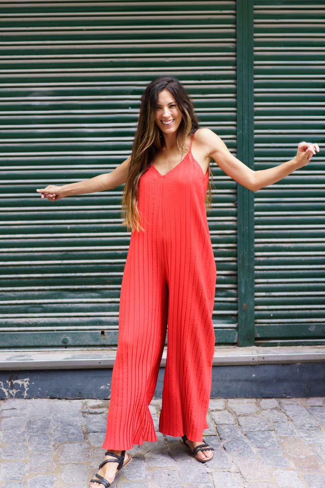 A Stylish Woman is spotted on an Urban Street wearing a Vibrant Red Jumpsuit that stands out
