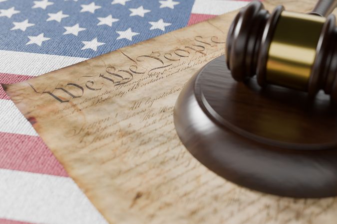 United States Constitution, Gavel and American Flag Resting on Table.