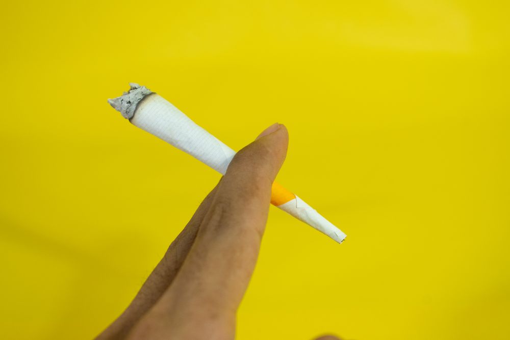 Hand holding burning cigarette
