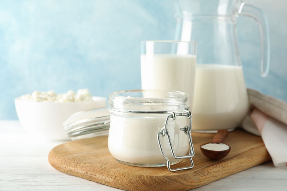 Fresh dairy products on plain wooden table, copy space