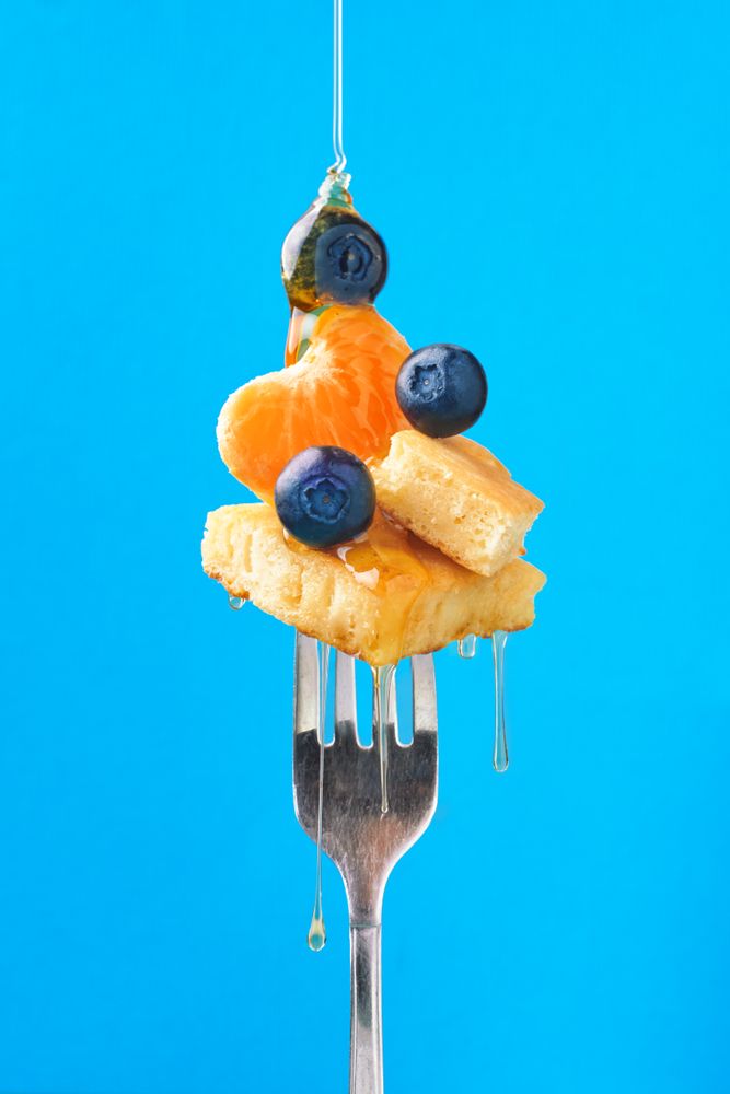 Appetizing fruit dessert with honey on fork