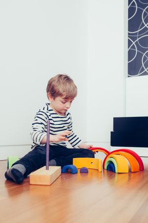 Boy playing with wooden construction pieces
