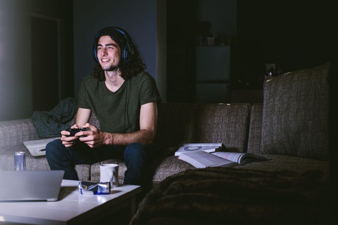 Happy student up late playing video games after day of studying