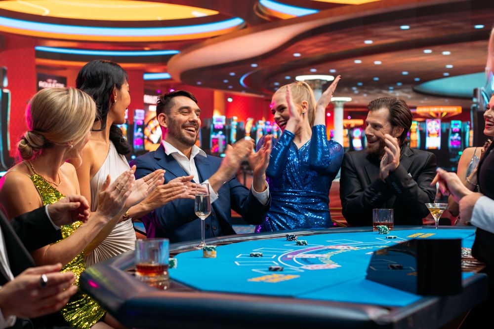 Group of Rich Glamorous People Playing Card at Blackjack Table on a Casino Floor.
