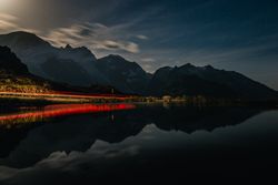 Red lit shore and water surface in mountains