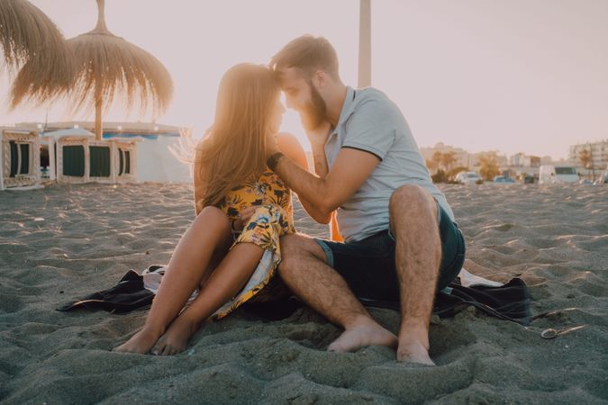 Tender couple kissing in sunlight on beach