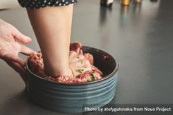 Woman’s hands mixing ground beef with herbs and spices bYmyGb