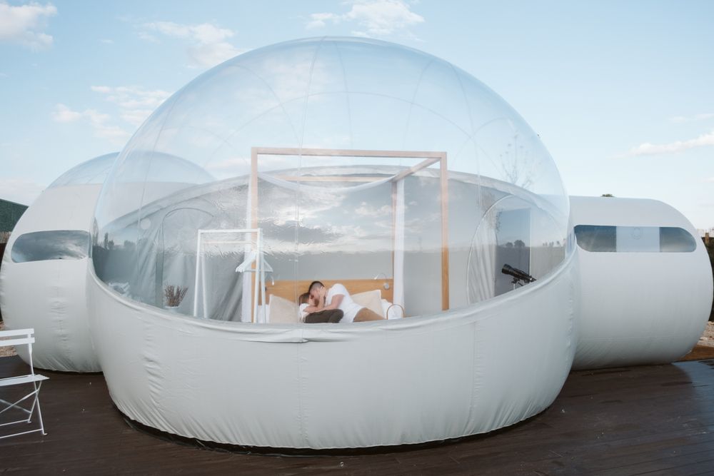 Passionate couple on bed in bubble hotel