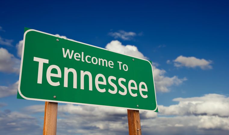 Welcome To Tennessee Green Road Sign Over Blue Sky with Some Clouds.