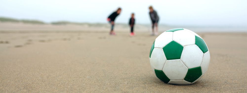 Close up of soccer ball with three people