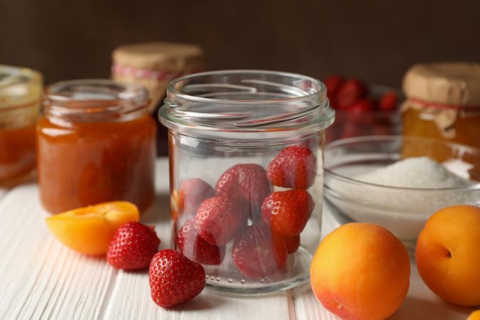 Composition with jam on wooden table. Preparing jam