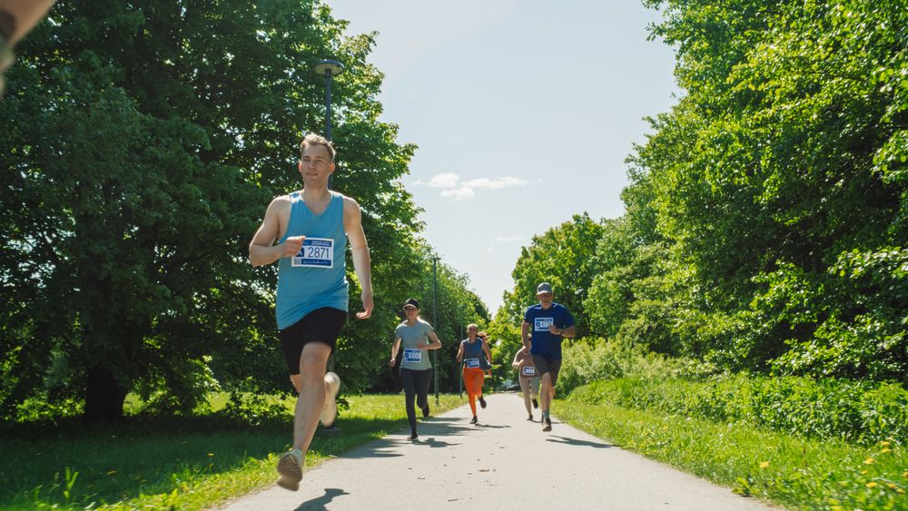 Portrait of a Diverse Group of People Participating in a Marathon and Running Through a Park Trail.