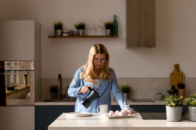 Woman pouring coffee in modern kitchen