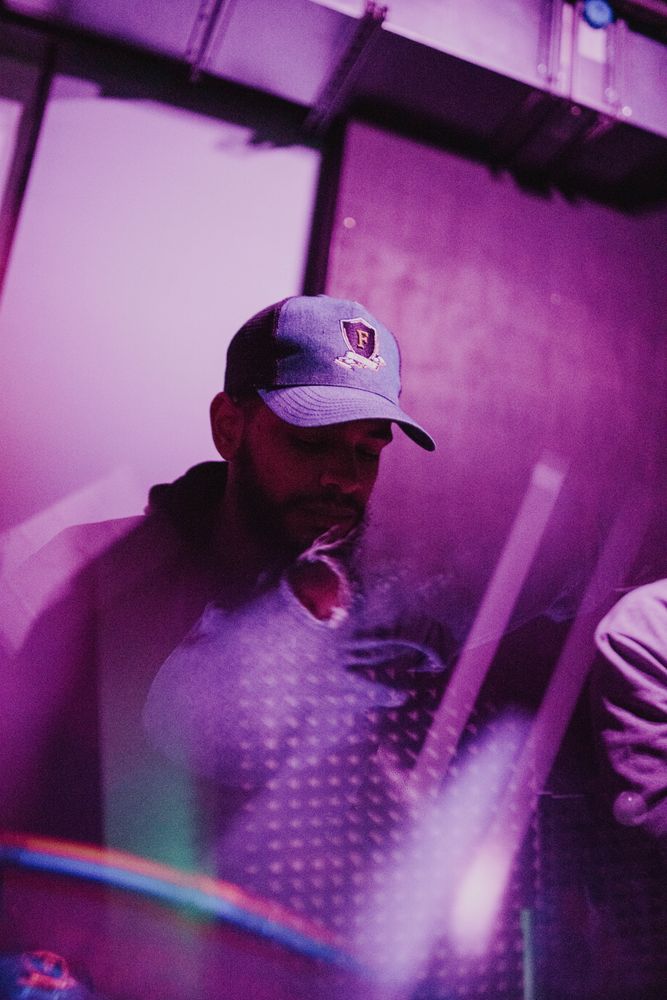 Purple and magenta tinted double exposure of young Black man in baseball cap