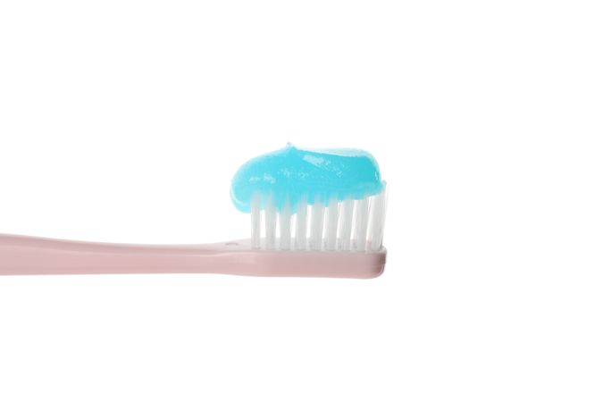 Toothbrush with toothpaste isolated on light background