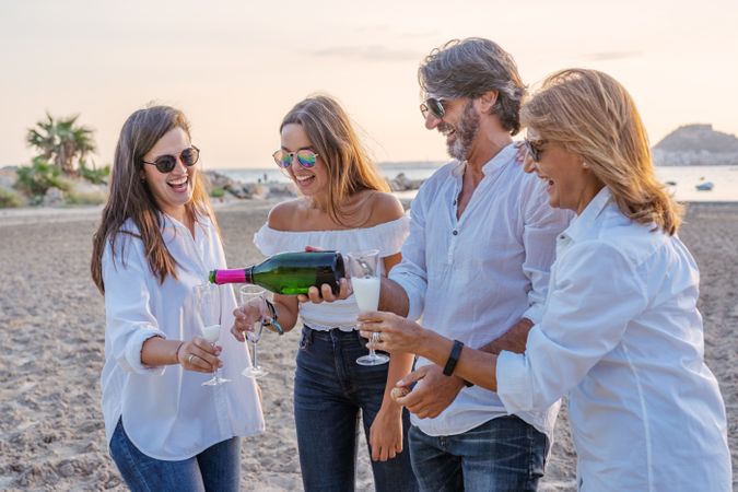 Happy family drinking wine on beach
