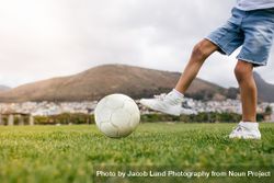 Crop of boy playing with soccer ball in a park 0WOEEW