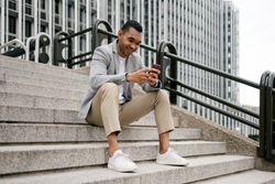 Man sitting on stairs using smartphone