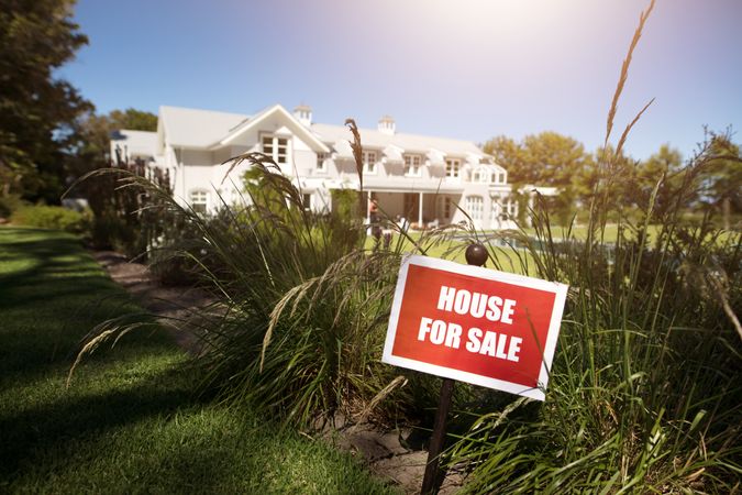 For sale sign in front of the house by real estate agency