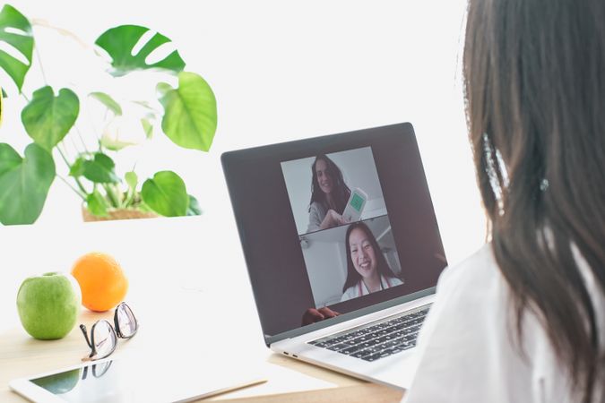 Asian doctor having video chat with patient via laptop