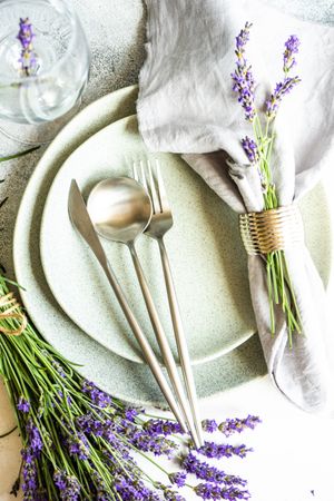 Delicate summer table setting with lavender flowers wrapped in napkin
