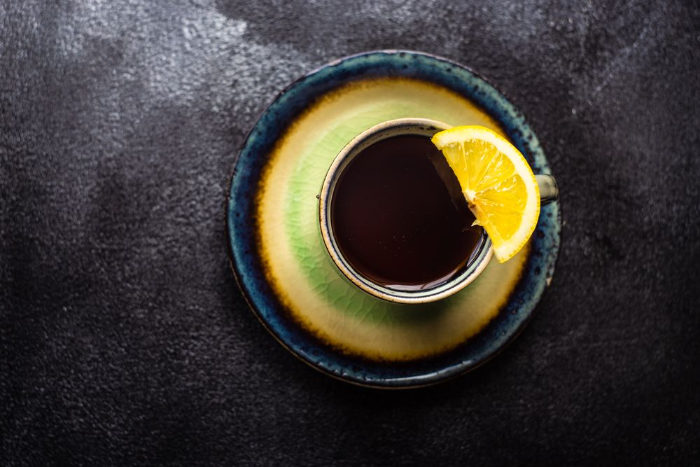 Top view of cup and saucer of tea and slice of lemon