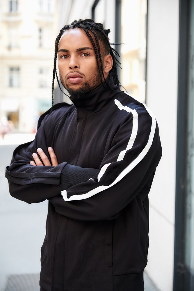 Black male standing with arms crossed