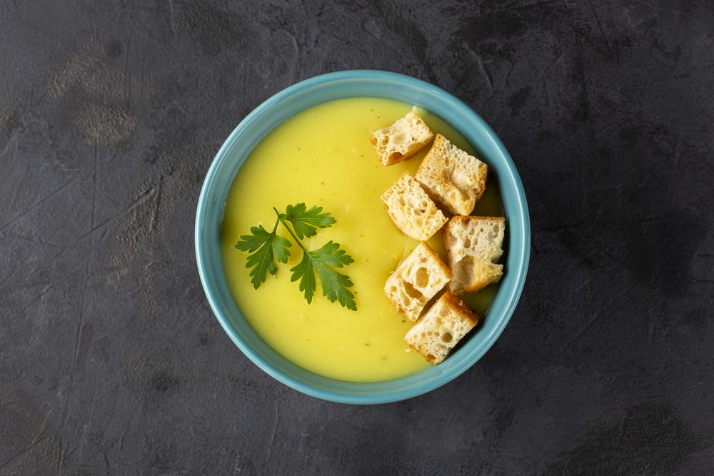 Bowl with onion soup and croutons on the table.