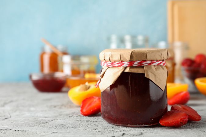 Composition with jam and ingredients on gray table, space for text