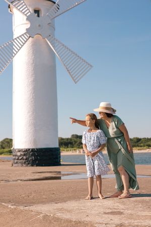 Girl and woman by windmill