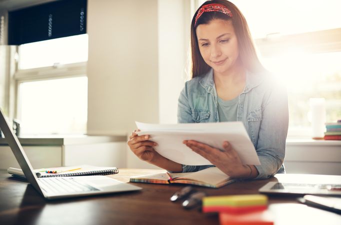 Woman reading notes at her desk