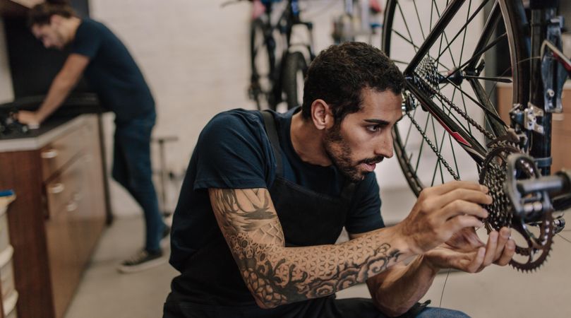 Man fixing a bicycle in a repair shop inside