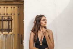 Female leaning on white wall