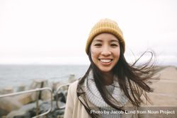 Young Asian woman smiling in yellow beanie 48Glj5