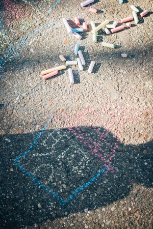 Colored chalk on pavement in sunny day