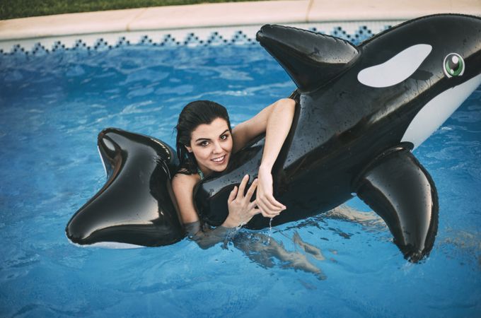 Brunette woman with inflatable toy posing in water