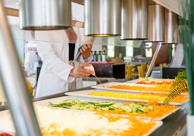 Adult employee checking food quality in canteen