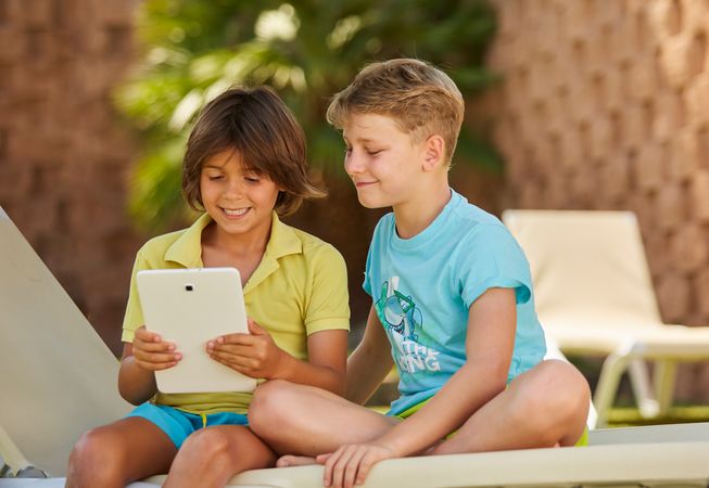 Boys using tablet in garden