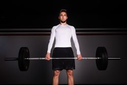 Man lifting barbell in gym