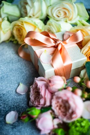 Pastel flowers on grey counter with giftbox